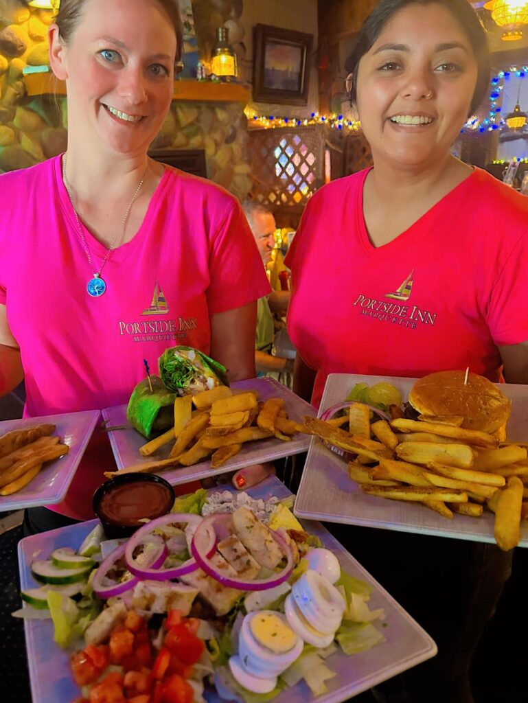 two servers with dinner plates at the Portside Inn restaurant in Marquette, MI